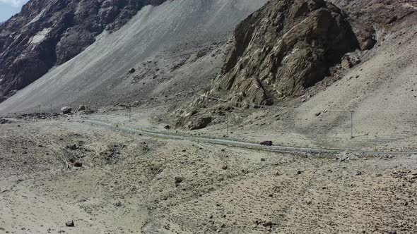 aerial drone of a fasting motorcycle driving on a road in the desolate empty roads of Skardu Pakista