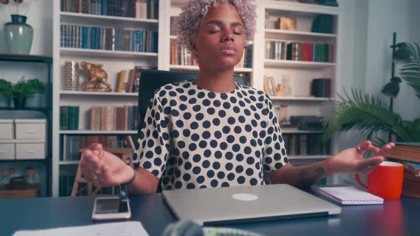 Focused Business Woman Meditates Sitting at Workplace in Office