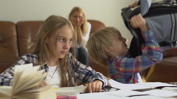 Little Boy and Girl Studying at Home in the Foreground While Their Mother Sitting in the Background