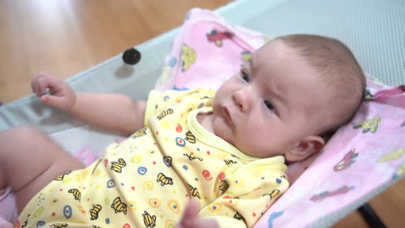 Newborn Mischievous in a Baby Rocking Chair