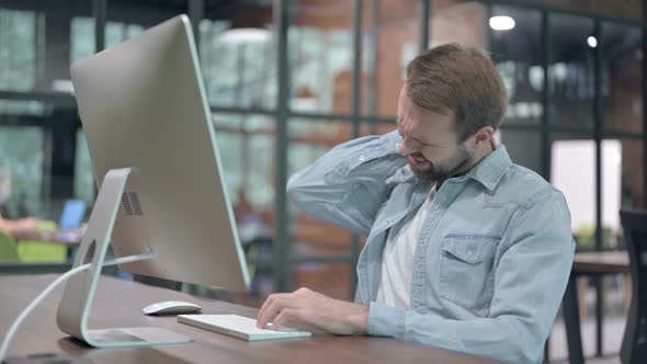 Young Man with Neck Pain at Work