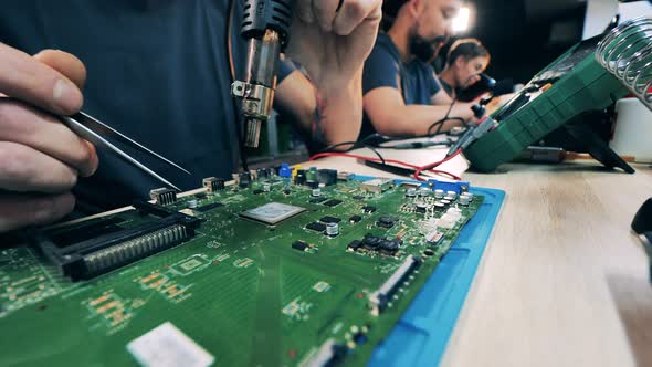 Male Specialist is Preparing to Solder a Laptop Circuit