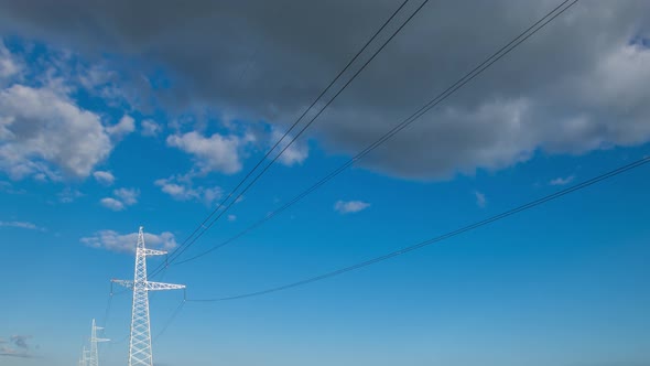 Wide Angle Power Transmission Lines High Voltage Electricity Grid with Cloudy Blue Sky and Sun Beams