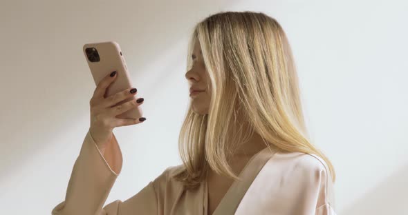 Young And Cute Blonde Looking In The Mirror, The Lady Is Taking Photos. Close Up