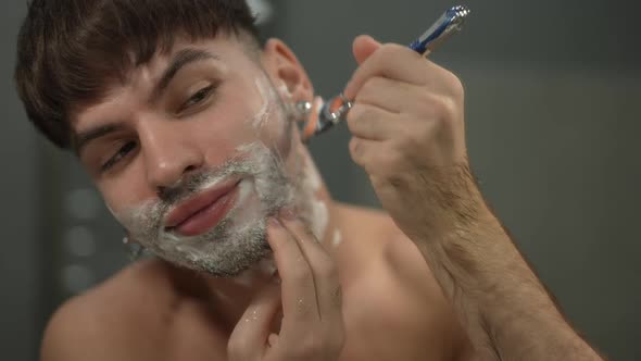 Closeup Front View Man Shaving Cheek Smiling in Slow Motion