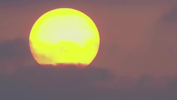 Time Lapse a Large Sun with Spot Sets in Dark Clouds