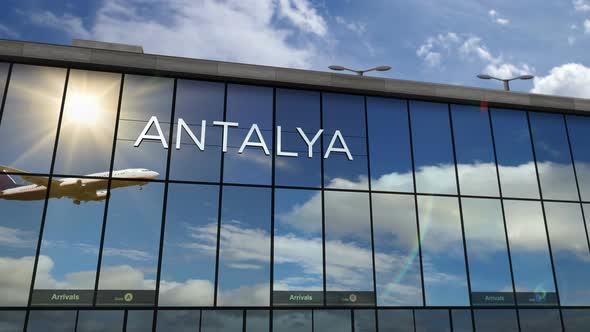 Airplane landing at Antalya Turkey airport mirrored in terminal