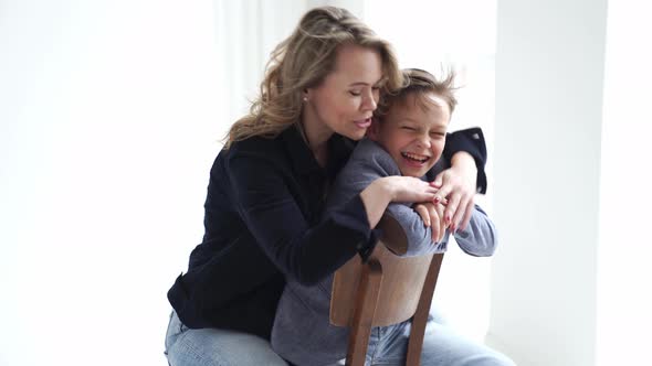 A Mother with Son in Blue Clothes Having Fun and Poses for a Photo Shoot