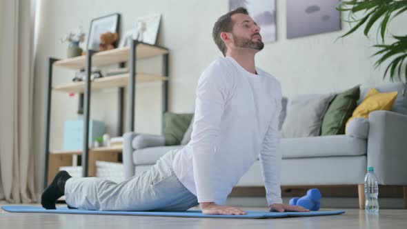 Man Doing Yoga on Yoga Mat at Home