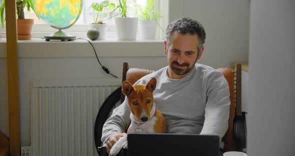 Man and His Dog Watch Videos on Laptop