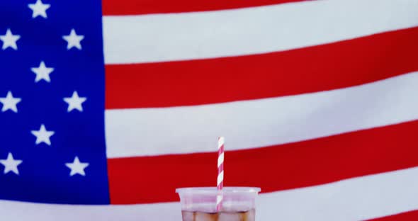 Hot dog and cold drink served against American flag