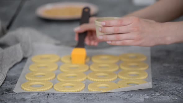 Female Hands Grease Cookies with Egg White at Kitchen