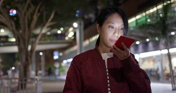 Woman use of mobile phone in city at night