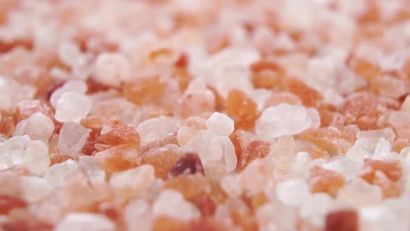 Falling rough crystals of Himalayan salt in slow motion. Macro