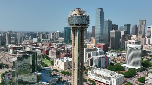 Dolly zoom pullback reveal of Reunion Tower and Dallas skyline. Aerial drone view.