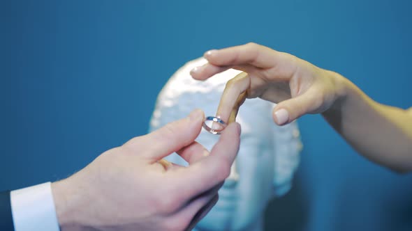 Close-up husband puts ring on bride's finger