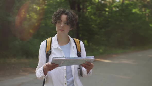 Girl Tourist Stands With A Map Looks Looking For A Route To Continue Moving, Girl Traveler Tourist