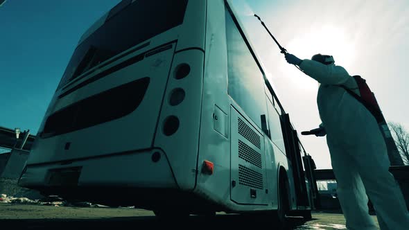 Sanitary Specialist Is Spraying Chemical Substance on the Bus