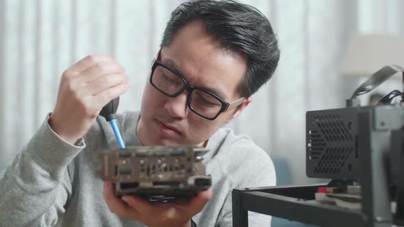 Close Up Of Asian Man Wearing Glasses Cleans The Graphic Card For Mining Cryptocurrency