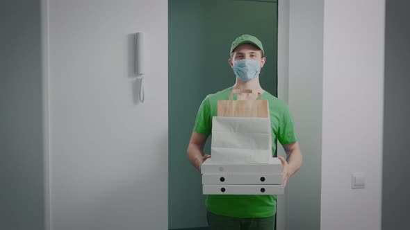 The Deliveryman Holds an Order with Food in His Hands