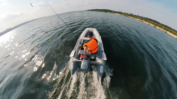 A Man in a Lifevest Is Onboard of the Motorboat