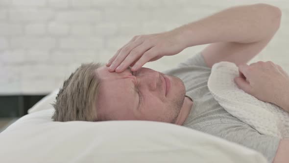 Man Having Headache in Bed