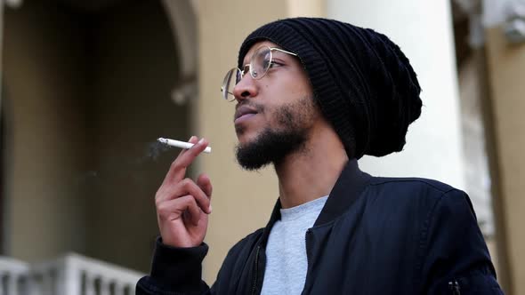 Stylish Pensive Man Takes a Puff of a Cigarette in Slow Motion Smokes on the Street