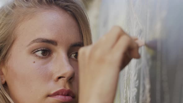 Portrait of beautiful blonde woman drawing