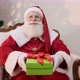Santa Claus offering a gift to the camera. Receiving Christmas presents. - VideoHive Item for Sale