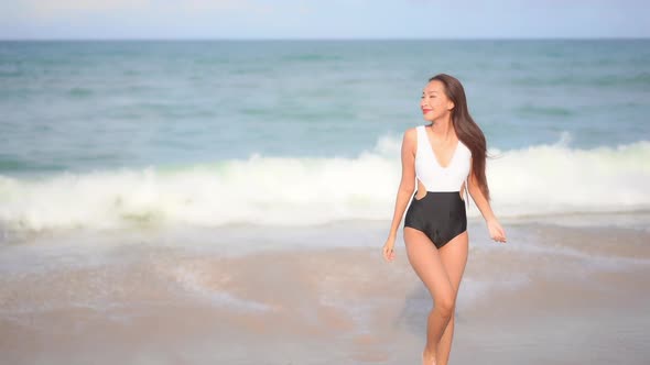 Asian woman enjoy around beautiful beach sea ocean