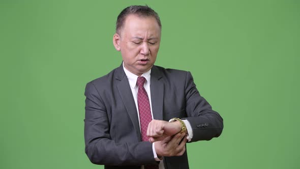 Mature Japanese Businessman Checking the Time