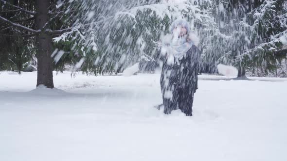 Teenage Girl Tosses Fresh Snow While Playing in Park