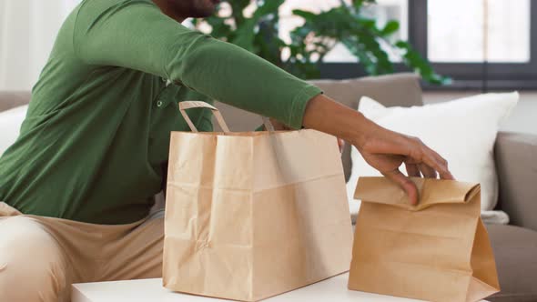 African Man Unpacking Takeaway Food at Home