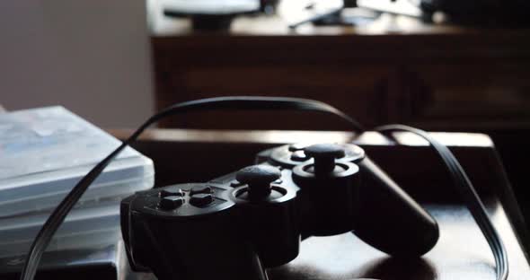 A video game controller and a composite video cable resting on a gaming desk.