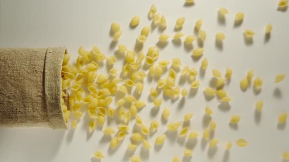 Bag Falls And Conchiglie Are Poured Out Of It On White Background