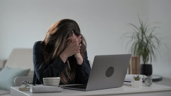 Pensive and serious young woman freelancer using laptop computer and  typing message