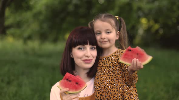 Happy Caucasian Mother and Her Cheerful Daughter Eating Watermelon in Summer Day Outdoor