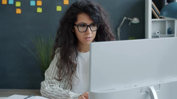 Happy Young Woman Enjoying Work Results Looking at Computer Screen Clapping Hands Smiling in Office