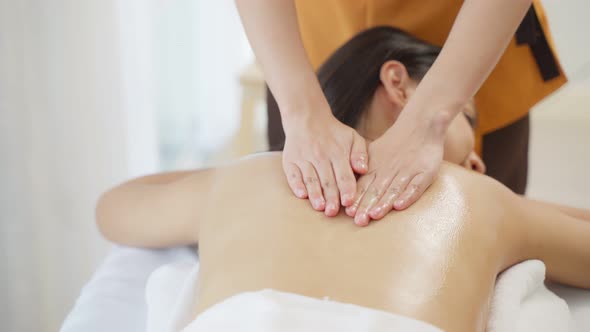 Asian young woman feeling happy and relax during back massage with oil.