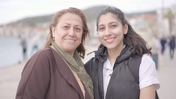 Old woman and young girl enjoying day outdoors in windy cool weather.