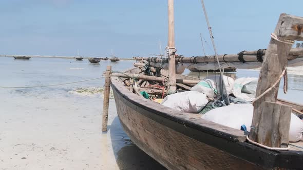 African Traditional Wooden Boat Stranded in Sand on Beach at Low Tide Zanzibar