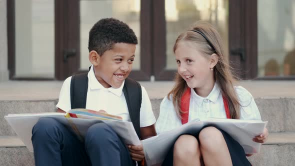 School Children Reading Book While Sitting on Stairs