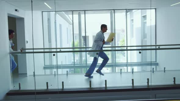 Male and female doctors running in the corridor at hospital