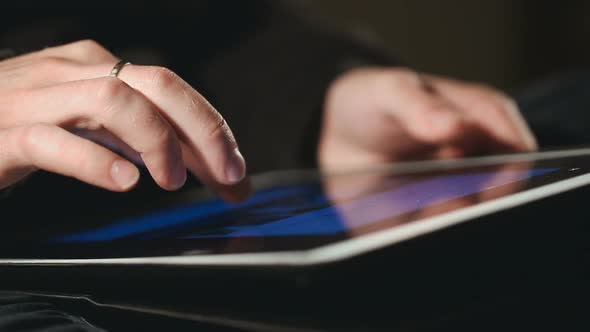 Man Scrolling and Scaling On His Tablet