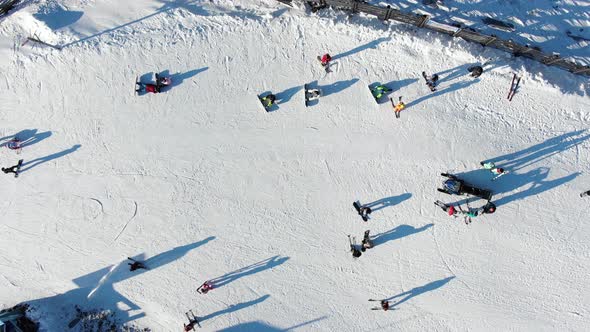 Active Tourist Silhouettes Ski on Resort Slope Upper View