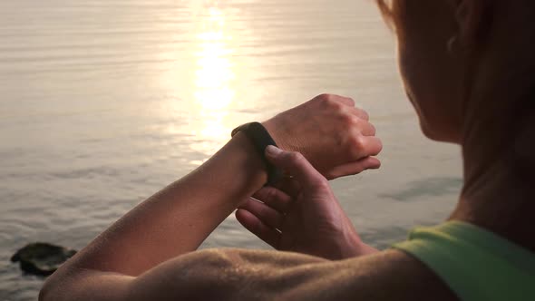 Sporty Female Using Fitness Bracelet Outdoors