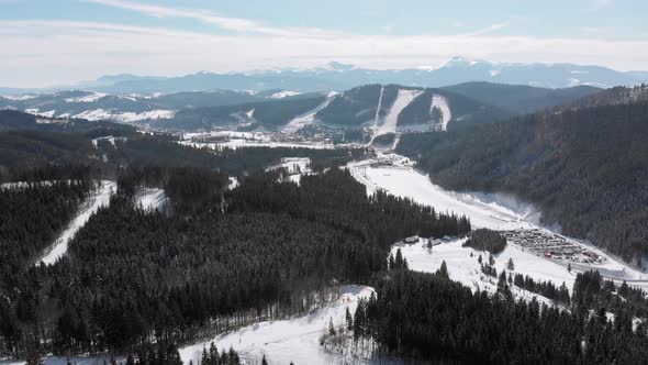 Aerial Ski Slopes with Skiers and Ski Lifts on Ski Resort. Snowy Mountain Forest