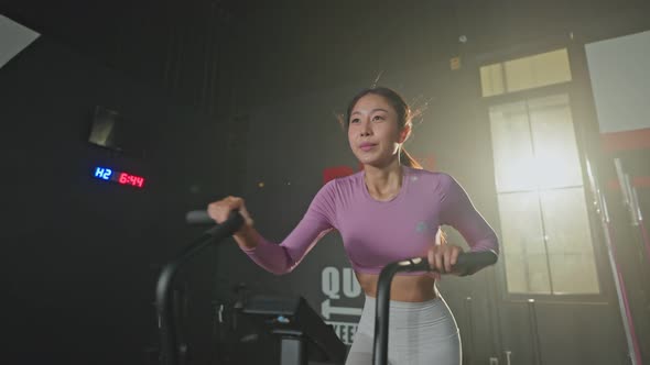Asian young athlete or sport woman practice working out to maintain muscle in gym or fitness club.