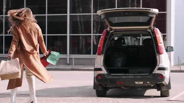 Happy Woman Shopoholic Is with Shopping Bags at the Car