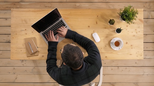 Happy young businessman ilooking at laptop excited by good